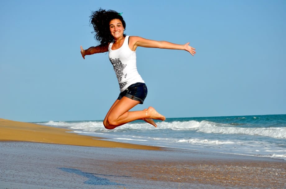 a woman jumping on the beach